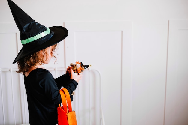 Free Photo little witch looking at her toy