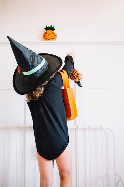 Free Photo little witch putting toys in bag