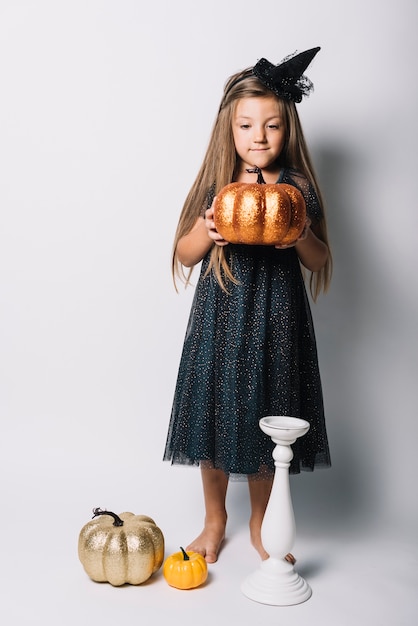 Free Photo little witch with fake pumpkin