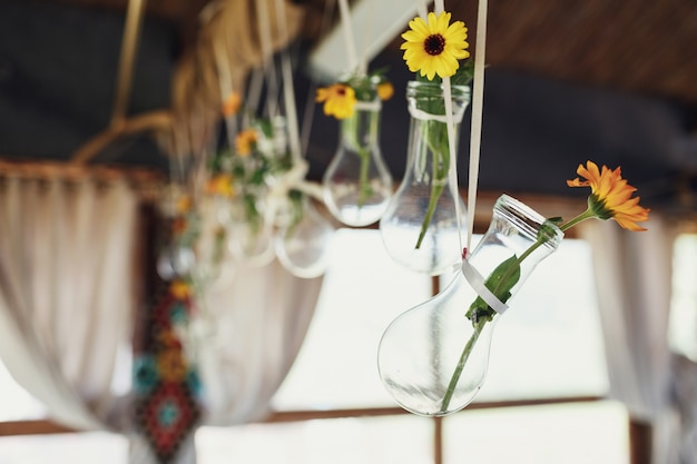 Little yellow daisies in the bulbs hang under the ceiling