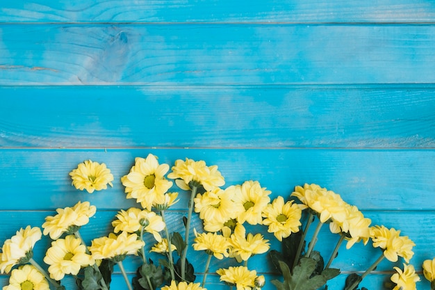 Free photo little yellow flowers on wooden table