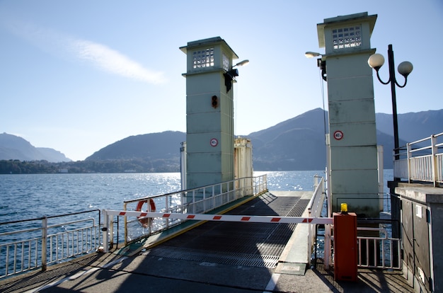 Loading dock at the end of a pier by the water with the mountains