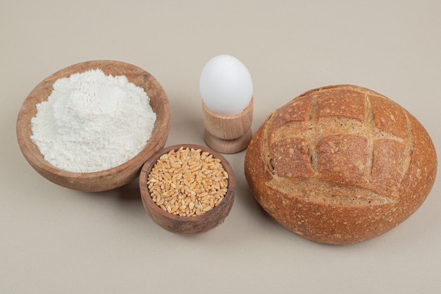 Loaf of bread with boiled egg and oat grains