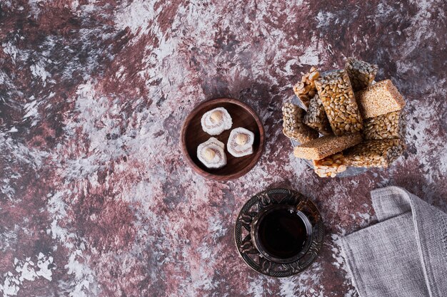 Lokum and sesame cookies with a glass of tea, top view