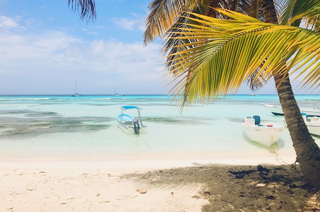 Lonely boats on turquoise water before golden beach