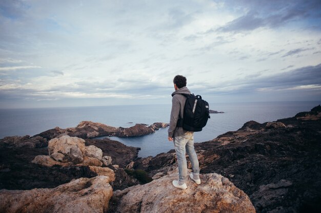 Lonely figure or adventurer and explorer with big backpack for drone