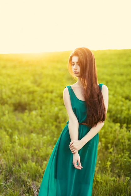 Free photo lonely girl on the meadow at sunset