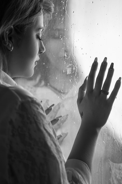 Free photo lonely girl near window thinking about something