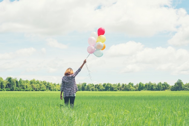 Free photo lonely girl with multicolored balloons