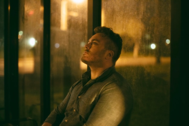 Lonely man at the bus station in the city at night