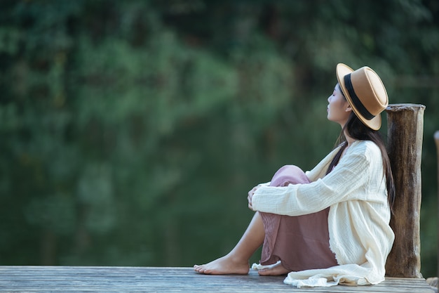 Lonely woman sitting on the waterfront raft