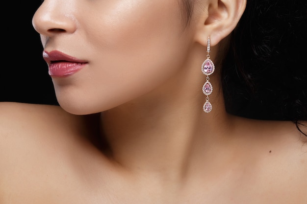 Long earring with violet precious stones hang from woman's ear