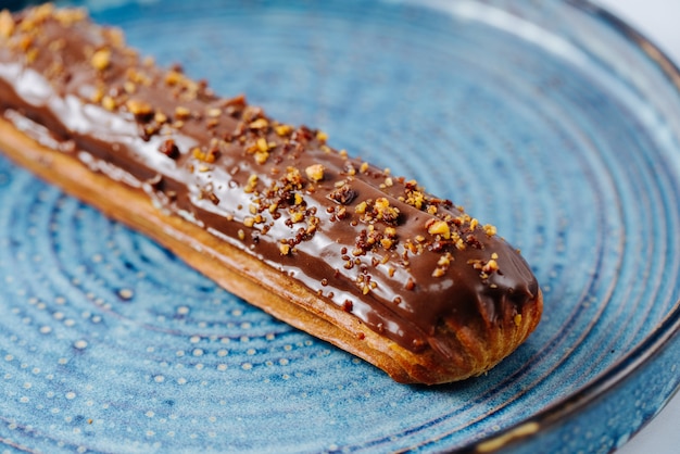 Free photo long eclair topped with melted chocolate and nuts