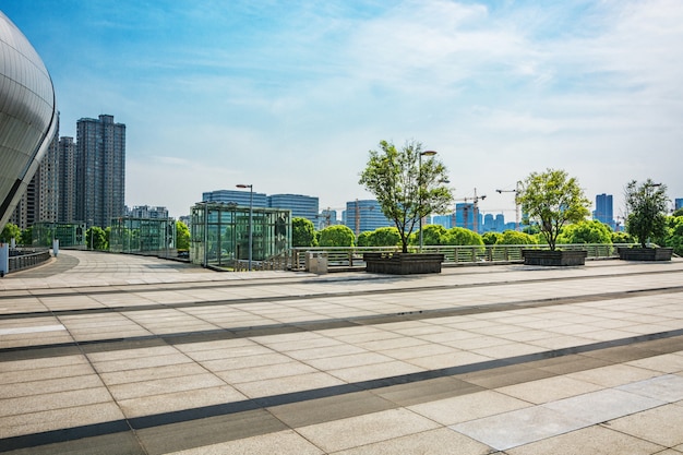 long empty footpath in modern city square with skyline.