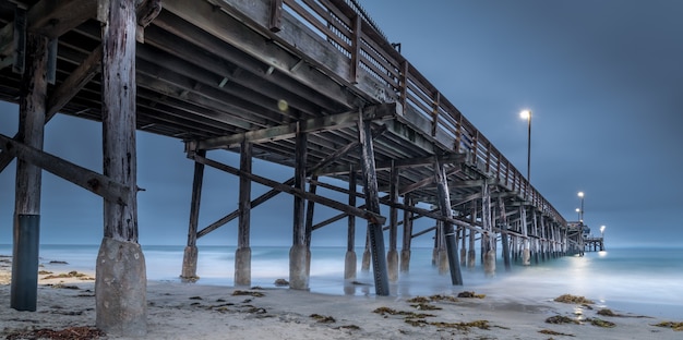 Long exposure of a wooden pier in the sea in California in the evening