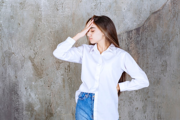 Free photo long-haired beautiful girl in white blouse having headache