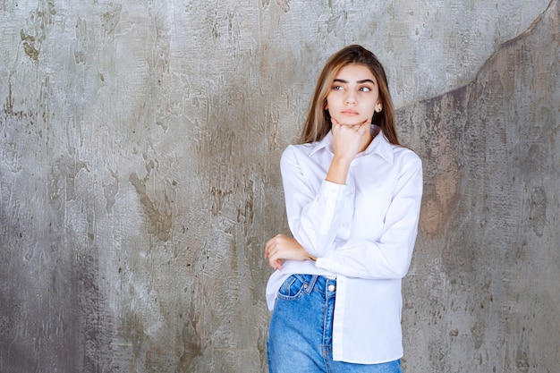 Free photo long-haired beautiful girl in white blouse thinking about something