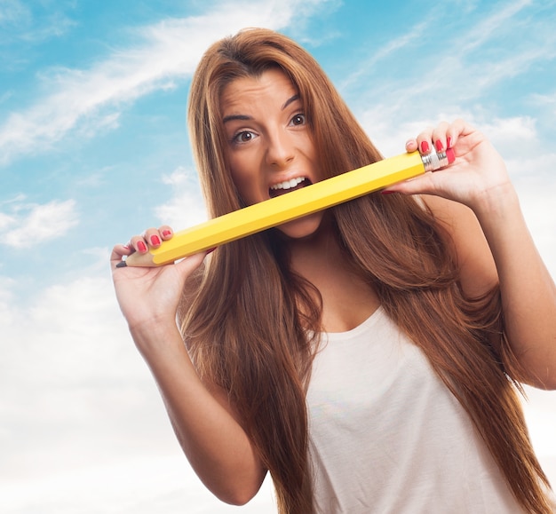 Free photo long-haired female crunching big pencil.