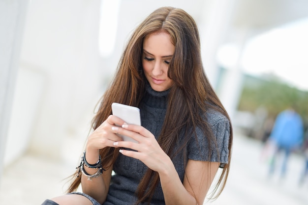 Free Photo long-haired girl texting on her mobile phone