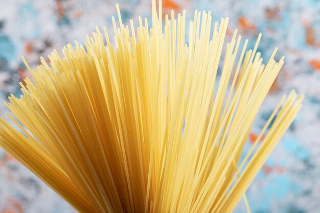 Long raw spaghetti on colorful.