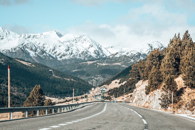 Free photo long road surrounded by high mountains with tops covered in snow