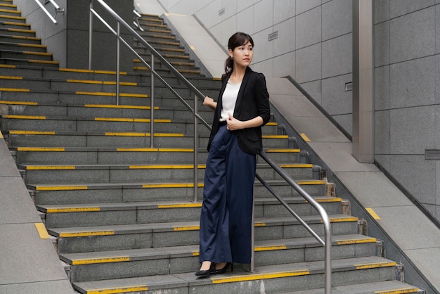 Long shot of beautiful business woman on stairs