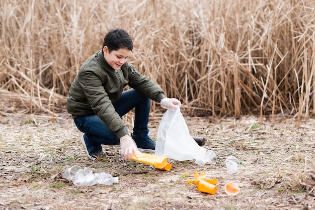 Free Photo long shot of boy cleaning the ground