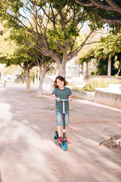 Long shot of boy with scooter