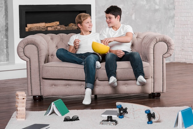 Long shot of boys sitting on couch