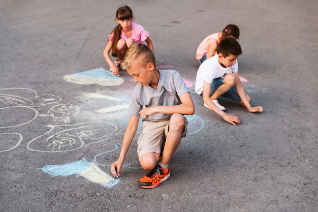 Free Photo long shot children making drawing with chalk 