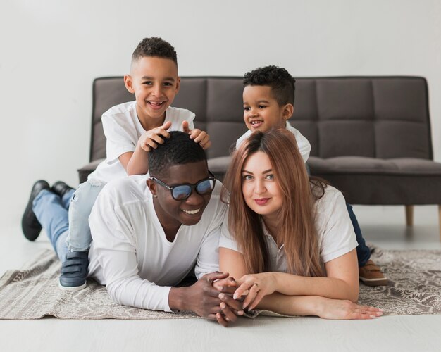 Long shot cute family spending time together on the floor