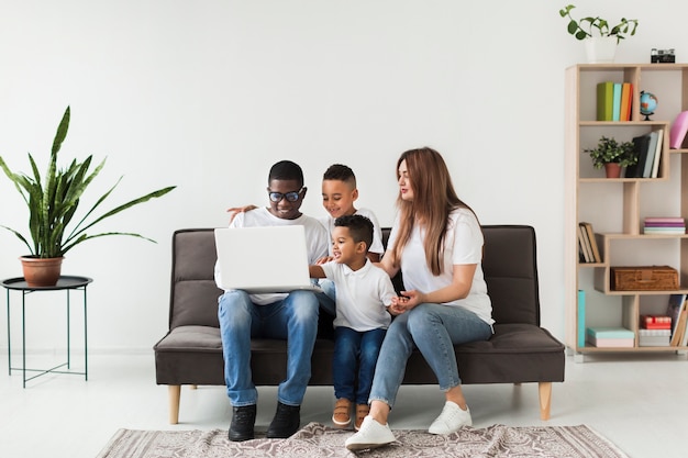 Long shot family looking on a laptop