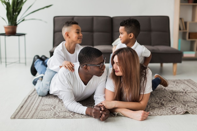 Long shot family relaxing on the floor