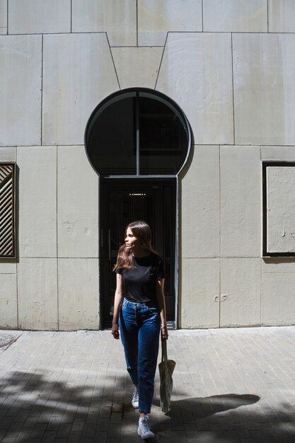 Long shot fashion woman holding a shopping bag