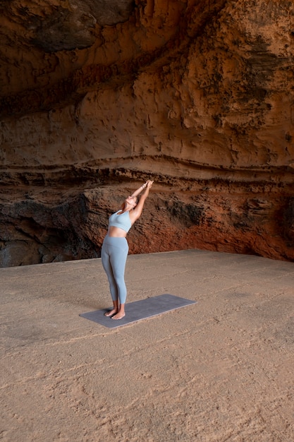 Free photo long shot fit woman doing yoga