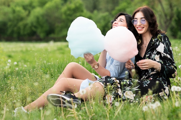 Free photo long shot friends eating cotton candy