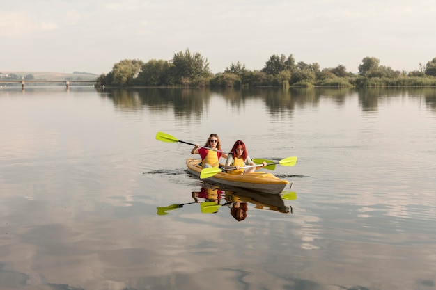 Long shot friends rowing in kayak