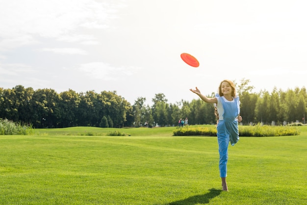 Long shot girl playing with frisbee 