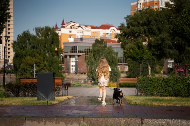 Long shot girl walking dog