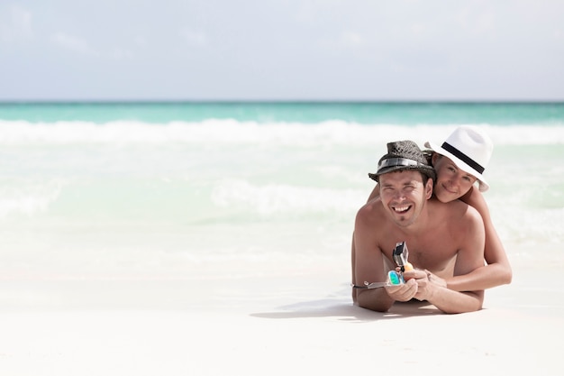 Free Photo long shot happy smiling couple at the beach