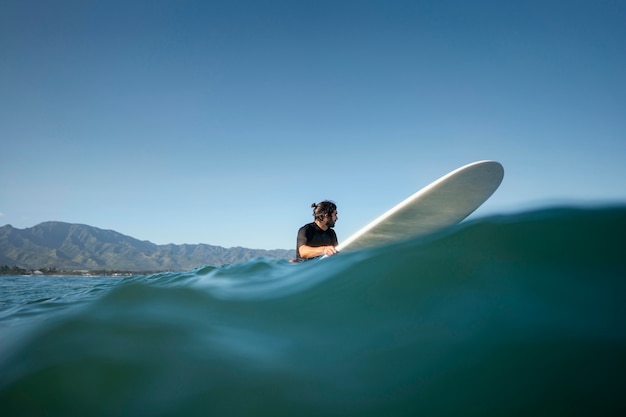 Free Photo long shot of man on his surfboard