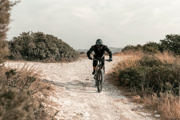 Free photo long shot man in mountain biking equipment