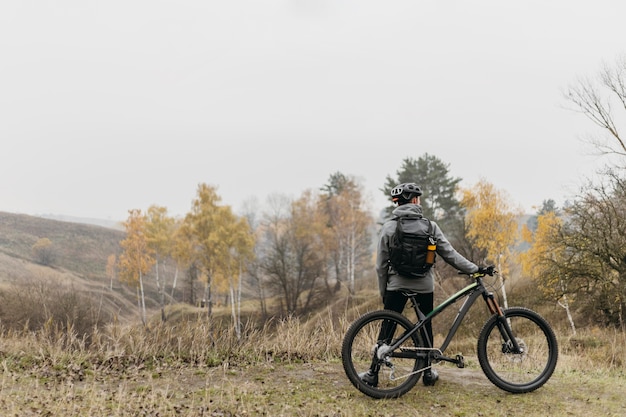 Free photo long shot of man riding a bike