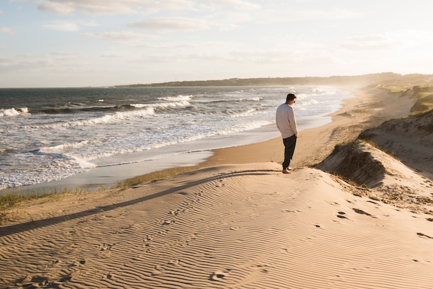 Free Photo long shot man walking on the beach