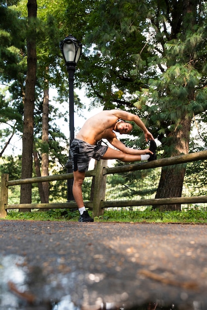 Free Photo long shot of runner stretching in park