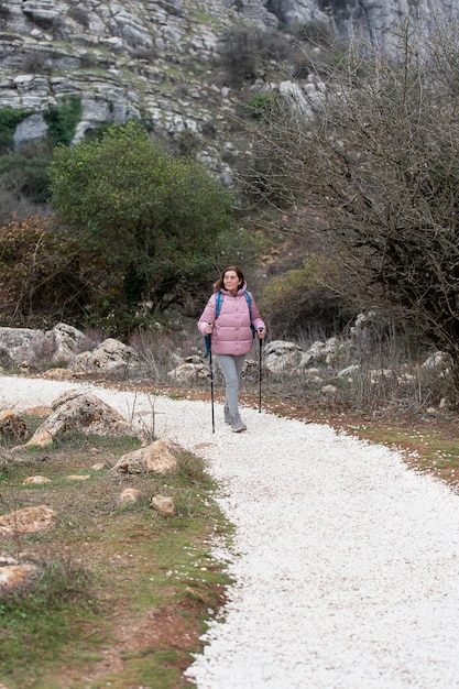 Long shot senior woman hiking