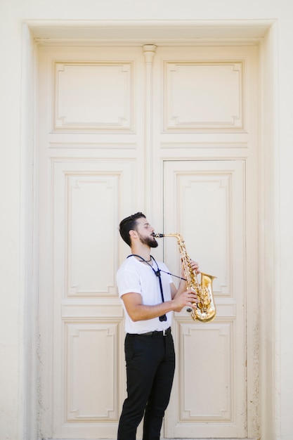 Free photo long shot sideways musician playing the saxophone