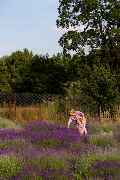 Free photo long shot woman and kid in lavender field