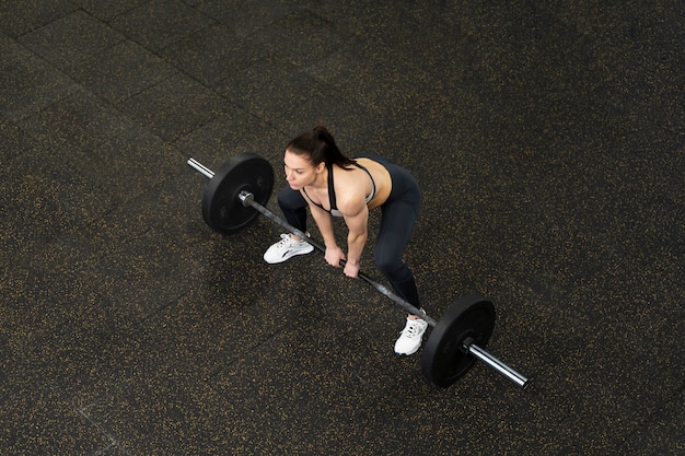 Free Photo long shot woman lifting dumbbell