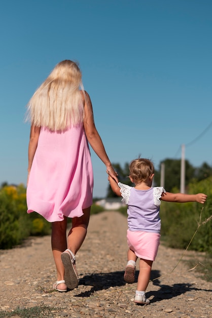 Long shot of a woman and little girl walking